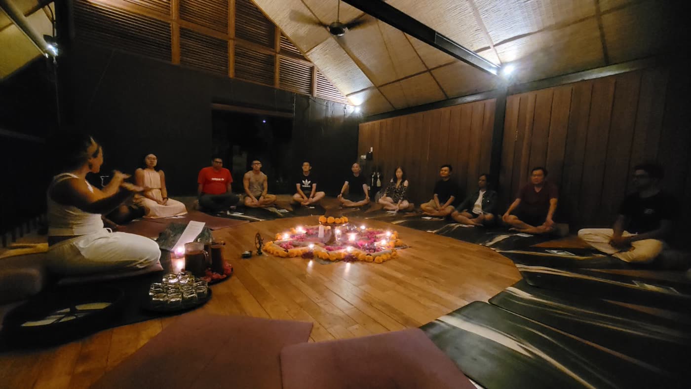 Mentors gathered around a candlelit cacao ceremony