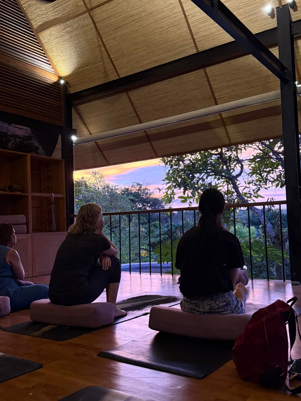 Mentors meditating facing a Bali sunset